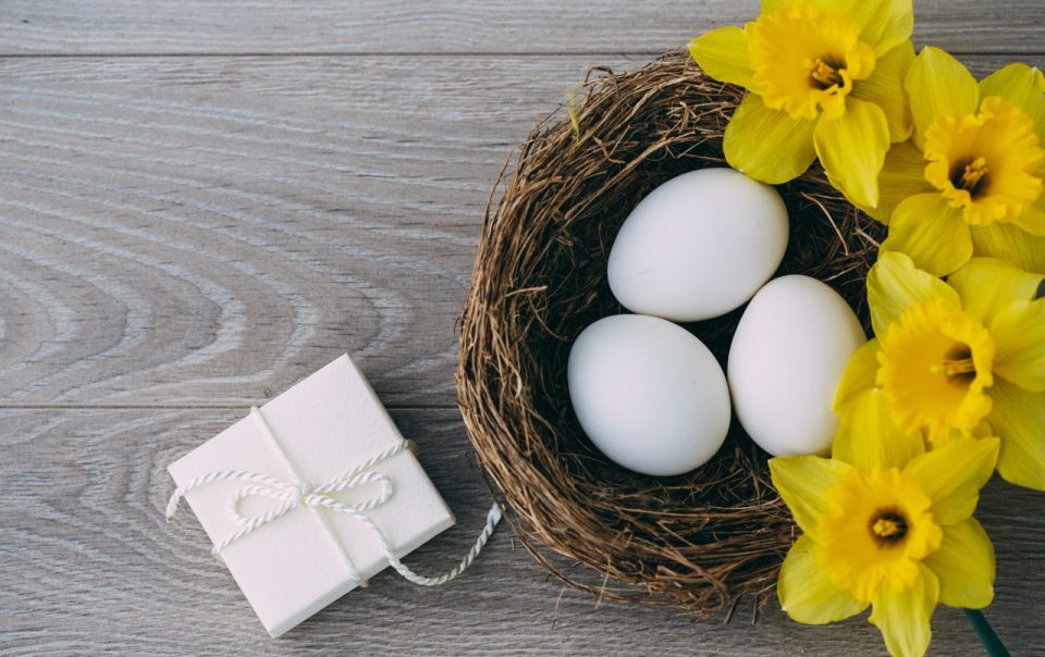 Eggs in a nest on a table next to a gift.